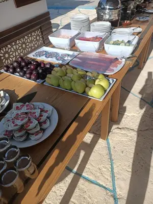 a wooden table with plates of food on it at vision suites Arbia Hurghada in Hurghada