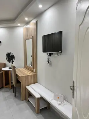 a room with a television on a wall with a desk at Scandic resort private beach in Hurghada
