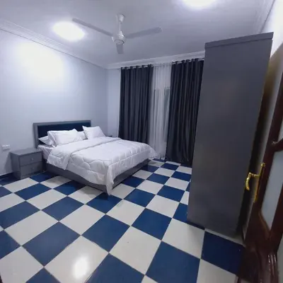 a bedroom with a bed and a checkered floor at شقة لاروز الغردقه الكوثر القديم شارع النور عماره لاروز in Hurghada