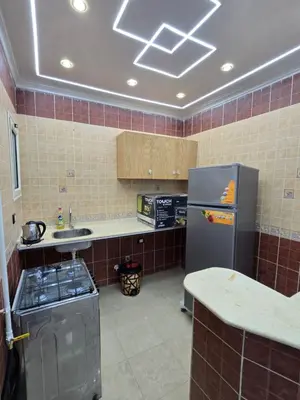 a kitchen with a stainless steel refrigerator and a counter at Larose Apartment in Hurghada