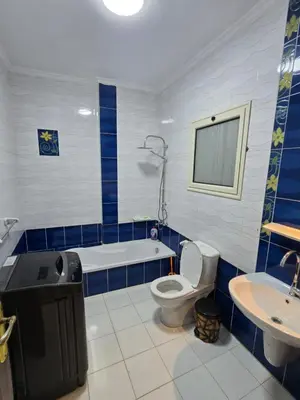 a bathroom with a tub and a toilet and a sink at Larose Apartment in Hurghada