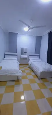a room with two beds and a ceiling fan at Larose Apartment in Hurghada