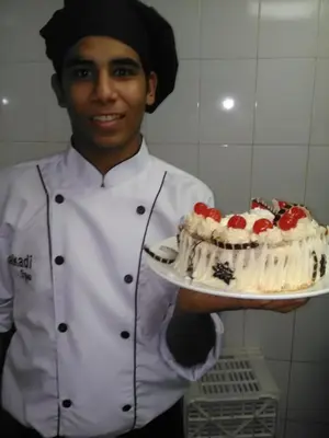 a chef is holding a cake on a plate at Lucky in Luxor