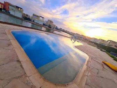 a person walking in front of a swimming pool at Gouna -tawila in Hurghada