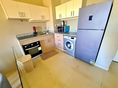 a kitchen with a refrigerator and a washing machine at Gouna -tawila in Hurghada
