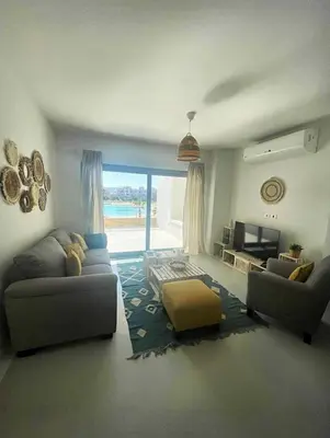 a living room with a couch and a tv at Spacious 2 BD with crystal Lagoon access in Gouna in Hurghada