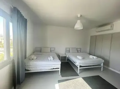 a white room with two beds and a window at Spacious 2 BD with crystal Lagoon access in Gouna in Hurghada