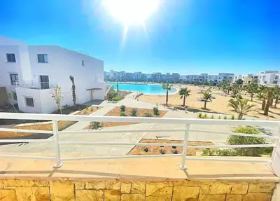 a balcony with a view of a beach and buildings at Spacious 2 BD with crystal Lagoon access in Gouna in Hurghada