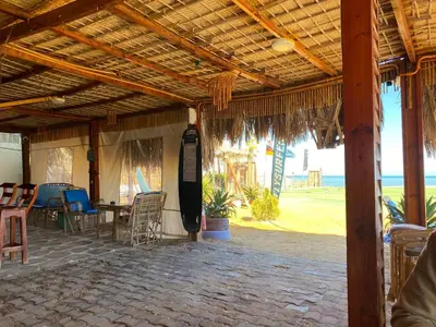 a patio with tables and chairs under a wooden roof at vintage sea view apartment in Hurghada