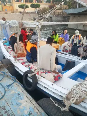 a group of people sitting on a boat in the water at جزيرة العوامية in Luxor