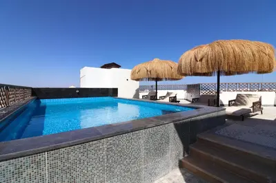 a swimming pool with umbrellas and chairs on a patio at Arаbian Suites by Imperial in Hurghada