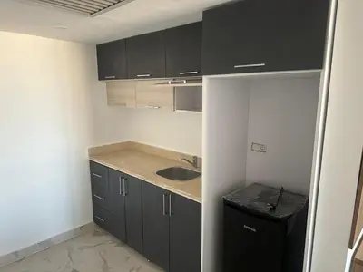a small kitchen with black cabinets and a sink at Sea view chalet hurghada in Hurghada