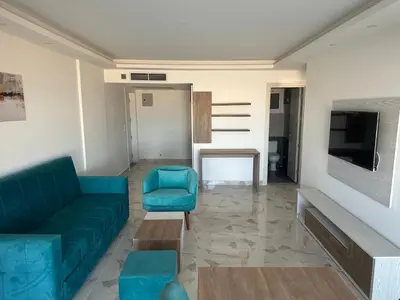 a living room with a blue couch and a tv at Sea view chalet hurghada in Hurghada
