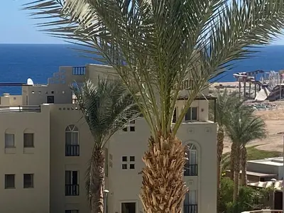 two palm trees in front of a building at Cozy Suite in Azzurra Resort Sahl Hasheesh 95 SqM in Hurghada