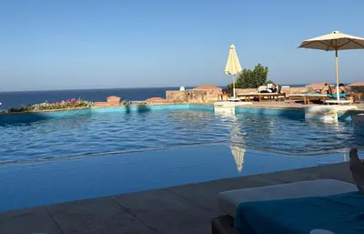 a swimming pool with a view of the ocean at Cozy Suite in Azzurra Resort Sahl Hasheesh 95 SqM in Hurghada