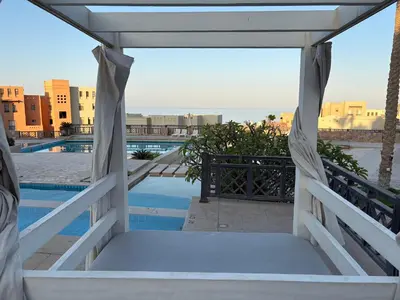 a room with a bed and a view of a pool at Cozy studio in Azzurra Resort Sahl Hasheesh 65 Sq M in Hurghada
