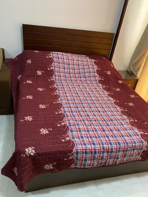 a bed with a red comforter on top of it at Taiba View Studio in Hurghada