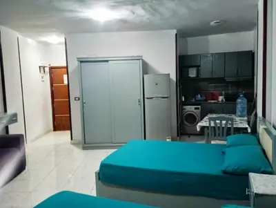 a living room with a blue bed and a kitchen at Taiba View Studio in Hurghada