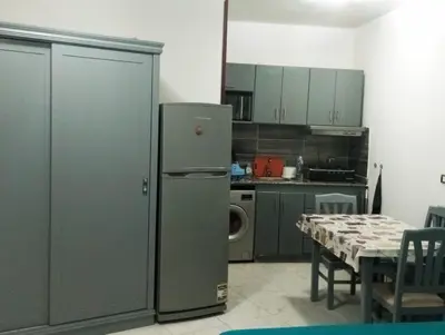 a kitchen with a stainless steel refrigerator and a table at Taiba View Studio in Hurghada