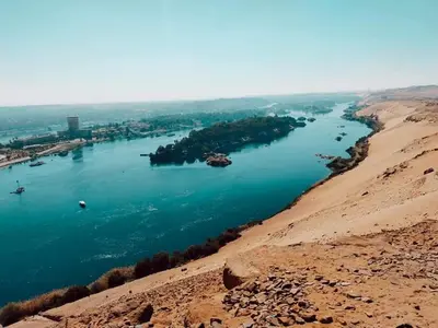 a view of a river from a hill at Sunset and Sand Felucca Life on the Nile in Jazīrat Aswān