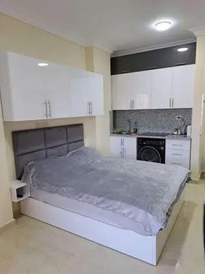 a bedroom with a large bed and white cabinets at Beachfront Studio Hurghada in Hurghada