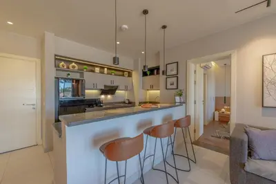 a kitchen with a bar with stools at Serene Lakeview Escape 2BR at Cyan ElGouna in Hurghada