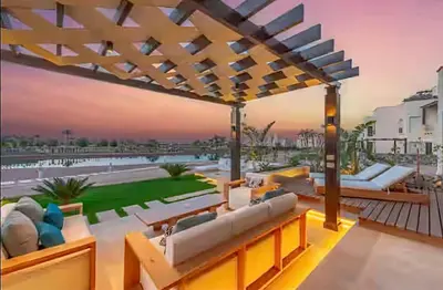a patio with couches and chairs on a building at Serene Lakeview Escape 2BR at Cyan ElGouna in Hurghada