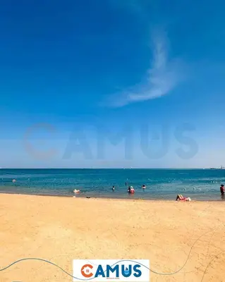 a beach with people swimming in the ocean at CAMUS 425 B, Princess Resort in Hurghada