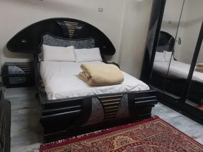 a bedroom with a black bed with a pillow on it at الاقصر امتداد ش التليفزيون in Luxor