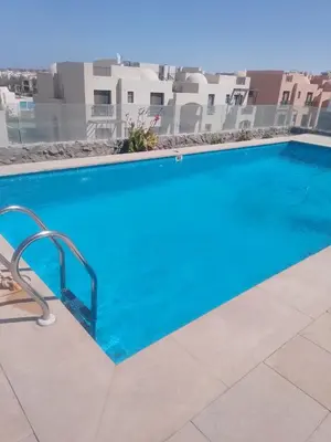 a large blue swimming pool in front of a building at Hurghada Apartment Makadi Lagon & Swimming Pools Free in Hurghada