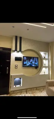 a living room with a flat screen tv on a wall at Nile palace apartment in Luxor