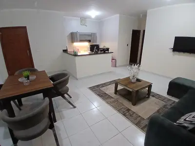a living room with a table and a kitchen at Yulla apartment in Hurghada
