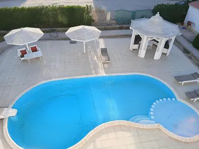 an overhead view of a swimming pool with a table and chairs at Villa yulla in Hurghada