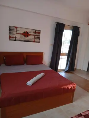 a bedroom with a large bed with a red blanket at Villa yulla in Hurghada