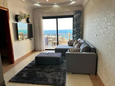 a living room with a couch and a view of the ocean at Palm View Paradise-Downtown Hurghada in Hurghada