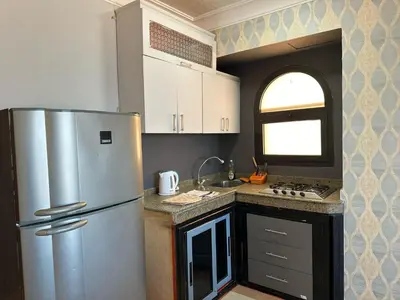 a kitchen with a stainless steel refrigerator and a window at Palm View Paradise-Downtown Hurghada in Hurghada