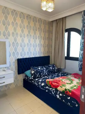 a bedroom with a bed with a blue headboard at Palm View Paradise-Downtown Hurghada in Hurghada