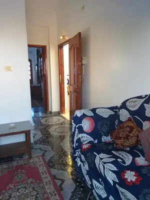 a living room with a blue couch in a room at Ziggy Marley Backpackers Hostel in Al Aqālitah