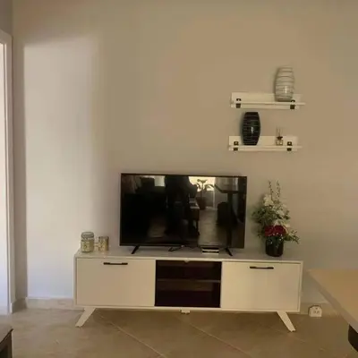 a living room with a flat screen tv on a white wall at West Side B 1 2 in Hurghada