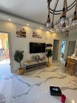 a living room with a television and a marble floor at The Retreat in Hurghada