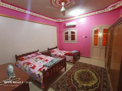 a bedroom with two beds and pink walls at elqusier redsea in Quseir