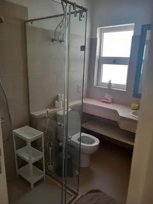 a bathroom with a toilet and a glass shower at Blue Lagoon View - 2 Bed 2 Bath - Shared Pool - El Gouna in Hurghada