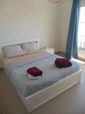 a bedroom with a bed with two towels on it at Blue Lagoon View - 2 Bed 2 Bath - Shared Pool - El Gouna in Hurghada