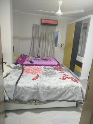 a bed in a room with a purple and white blanket at Flat in villa San George in Hurghada