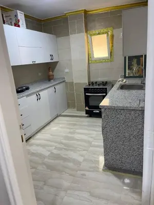 a kitchen with white cabinets and a sink and a stove at Aven Resort Compound in Hurghada