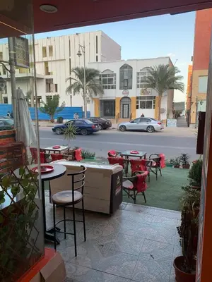 a patio with tables and chairs and a street at 2 Bedroom in Andreas Residence in Hurghada