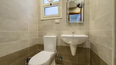 a bathroom with a toilet and a sink at Elite AlDaU Heights in Hurghada