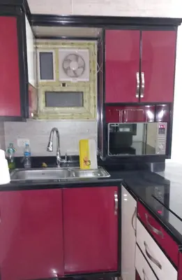 a kitchen with red cabinets and a sink and a microwave at الغردقة in Hurghada