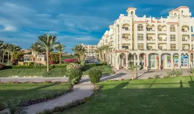 a large white building with palm trees and a park at Sea view Luxury apartment at Al Andalous Sahl Hasheesh in Hurghada