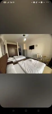 a bedroom with two beds and a television in it at شقه فردين مطله علي حمام السباحه في الغردقه in Hurghada